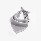 Cloud grey silk square folded to a triangle and knotted like a bandana, woven label showing