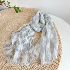 Blue botanical linen scarf draped to show its length and light weight