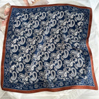 The whole navy square flat, cream and pale blue paisley inside a wide rust border