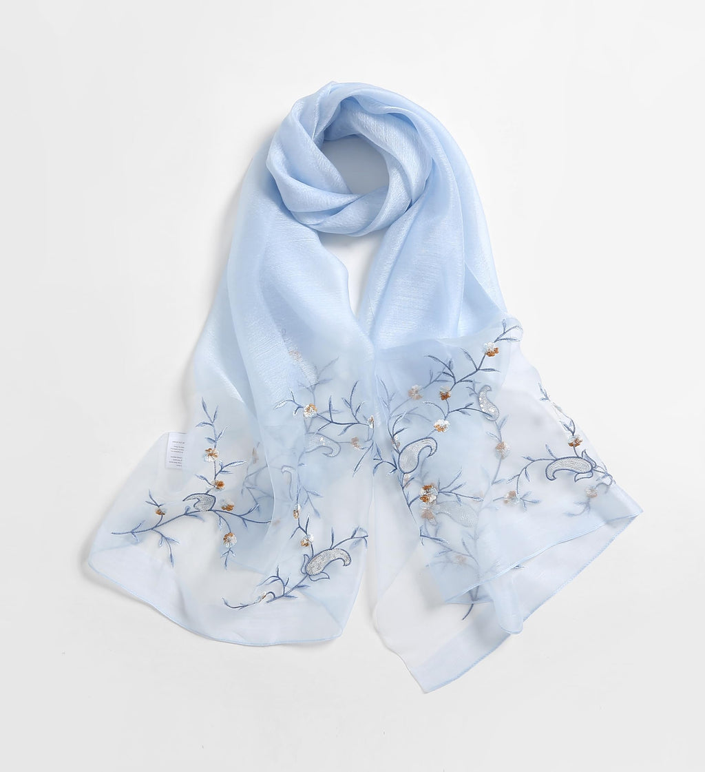 Pale blue shawl laid flat with fine trailing vine embroidery and sequin accents