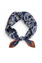 Navy paisley silk square knotted into a loop, rust border tails pointing down