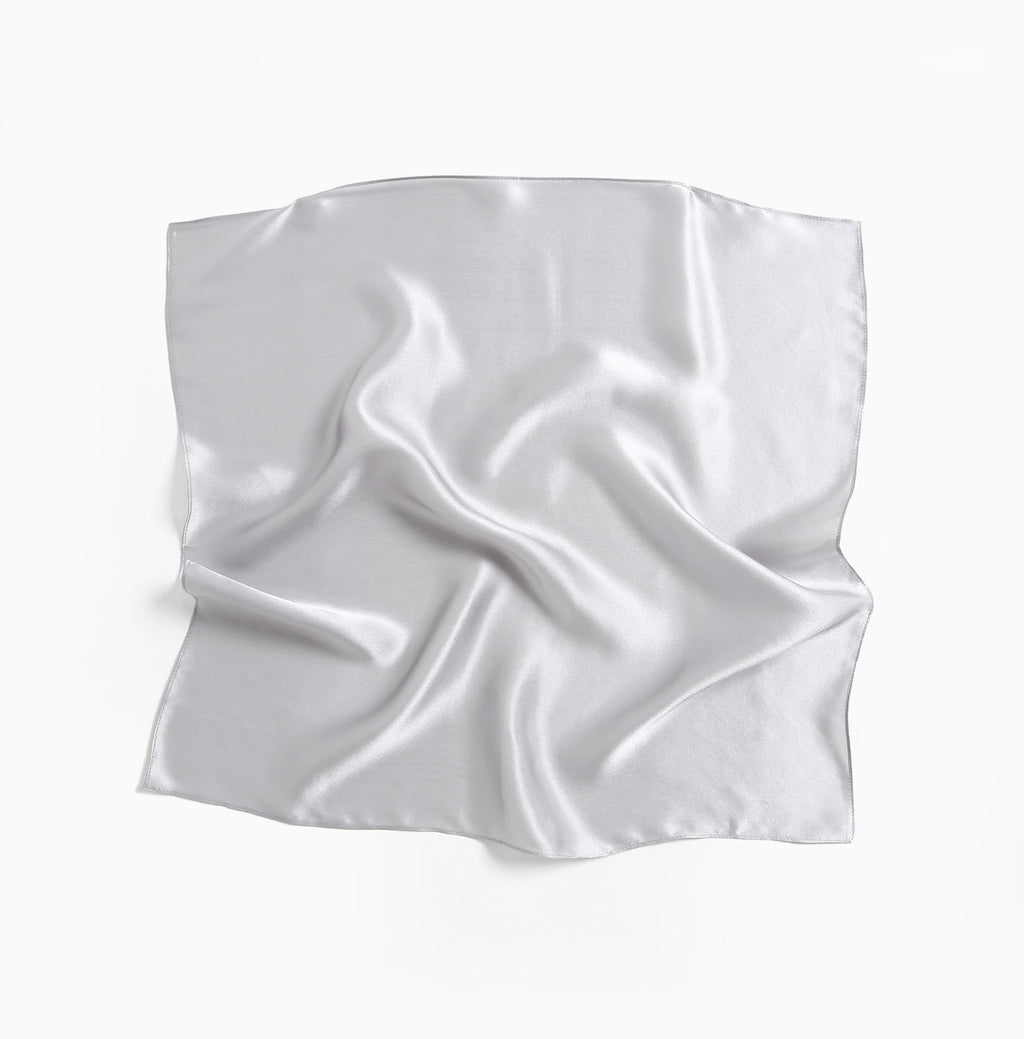 Full cloud grey silk square laid flat, light rippling over the plain charmeuse face