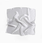 Full cloud grey silk square laid flat, light rippling over the plain charmeuse face