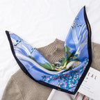 Blue silk square with sailboats on water and small purple blooms along one edge, black border