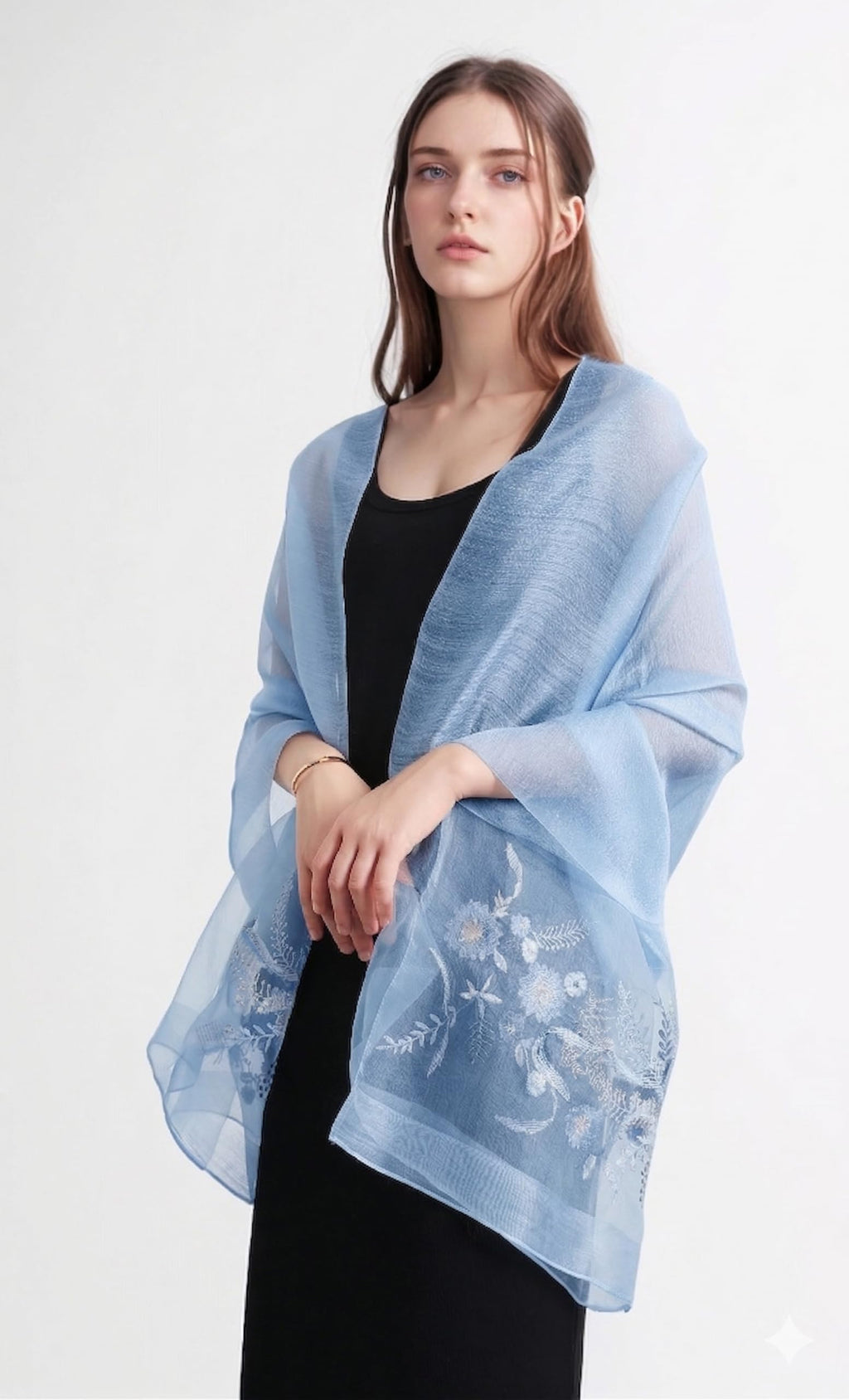 Model wearing the denim blue embroidered shawl draped open over a black dress