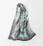 The pale blue shawl hanging in soft folds with the brown fringed ends visible at the bottom