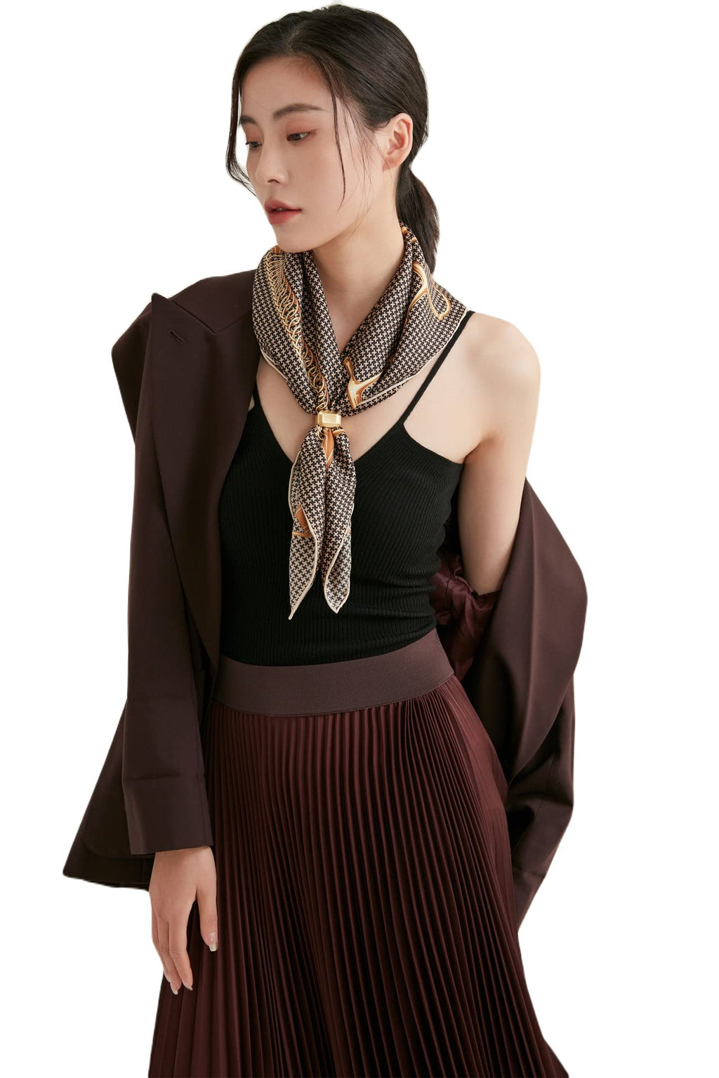 Woman in a brown blazer wearing a brown and cream houndstooth silk neckerchief with a gold saddle chain border