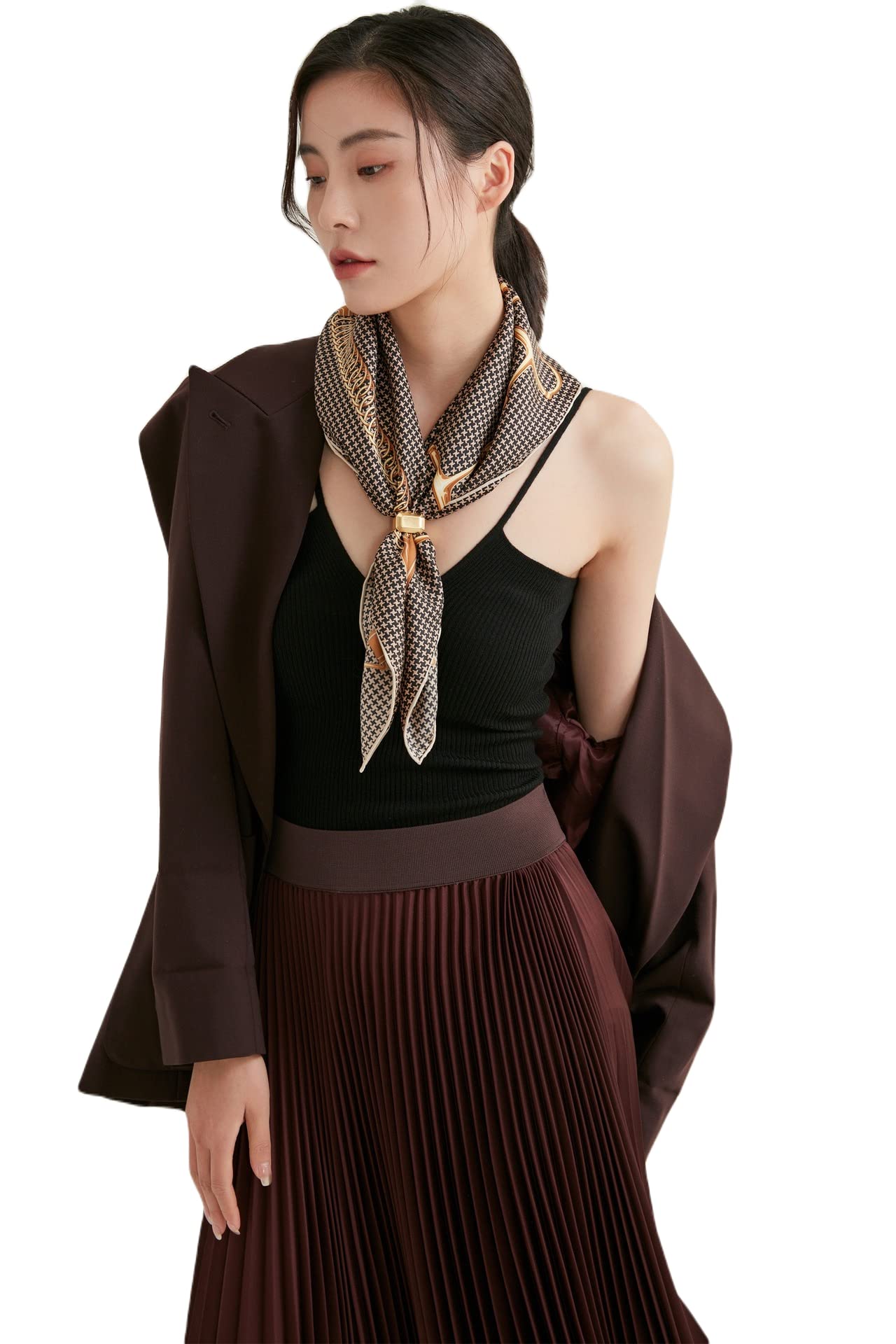 Woman in a brown blazer wearing a brown and cream houndstooth silk neckerchief with a gold saddle chain border