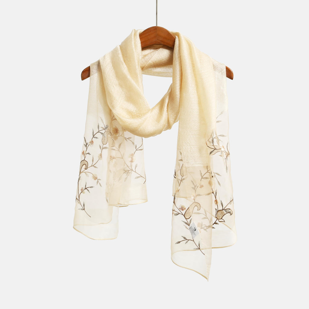 Khaki gold shawl on a hanger showing trailing vine embroidery on both ends