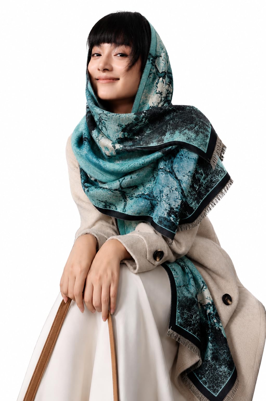 Woman with the teal marbled ink shawl drawn over her head and shoulders above a cream coat