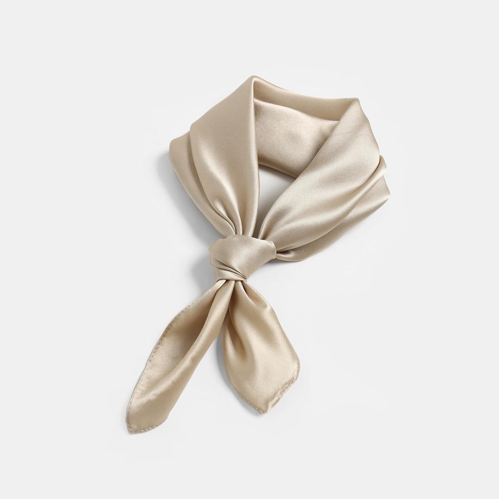 Champagne beige silk square knotted at the front, loop opened out on a grey backdrop