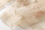 Sheer champagne border folded back against the embroidered panel