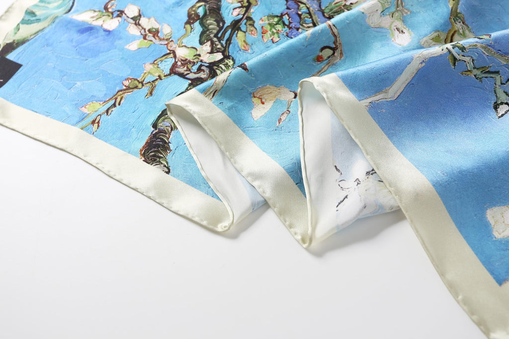 The almond blossom silk scarf in loose folds showing the depth of the blue ground