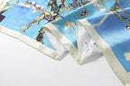 The almond blossom silk scarf in loose folds showing the depth of the blue ground