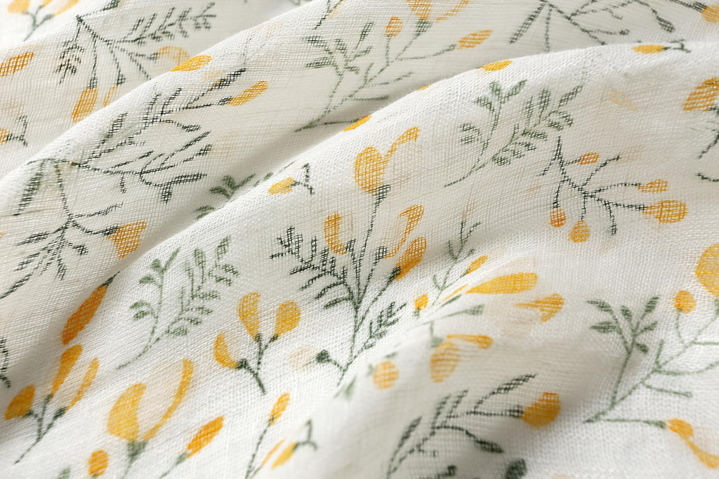 Yellow botanical linen scarf knotted at the waist over a swimsuit