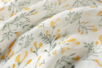 Yellow botanical linen scarf knotted at the waist over a swimsuit