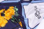 Close up of the brushed yellow flower painted on the navy panel of the silk scarf