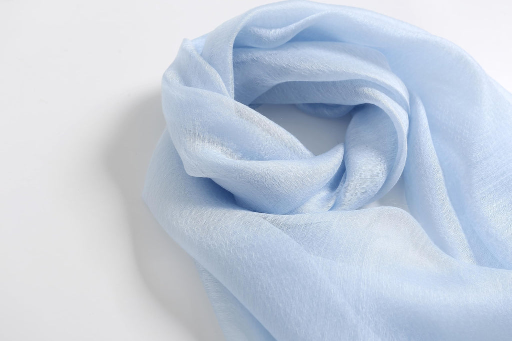 Pale blue shawl coiled showing the soft crinkled texture