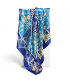 The cobalt folk art silk scarf hanging in long folds showing tulips and cottages