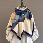 The shawl wrapped around a dress form over a cream coat with the navy reverse turned out at the neck