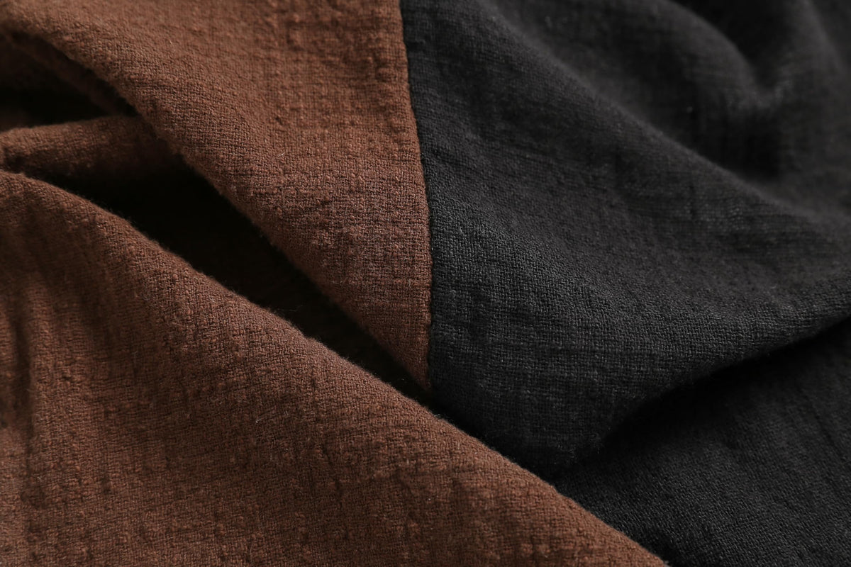 Detail of the scarf laid flat showing the two tone split and the fine bound edge