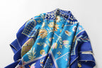 The cobalt folk art silk scarf folded to show the border and corner motifs