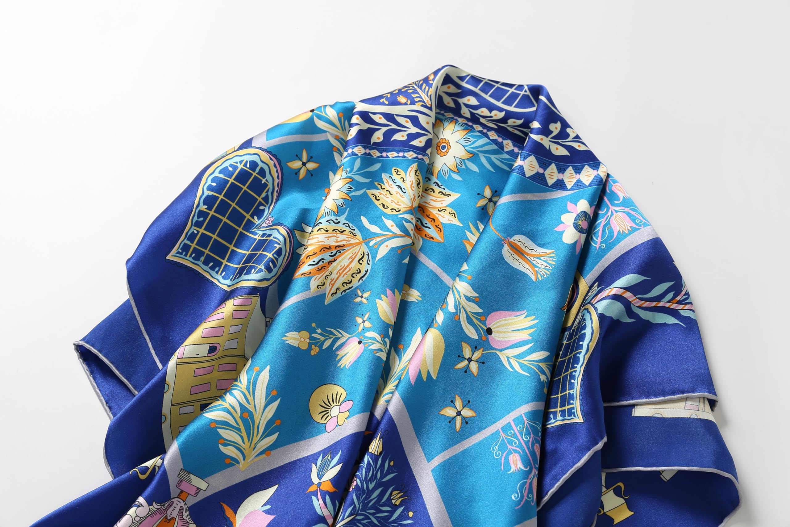The cobalt folk art silk scarf folded to show the border and corner motifs