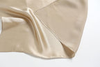 Diagonal fold of champagne beige silk with the stitched hem running across the corner