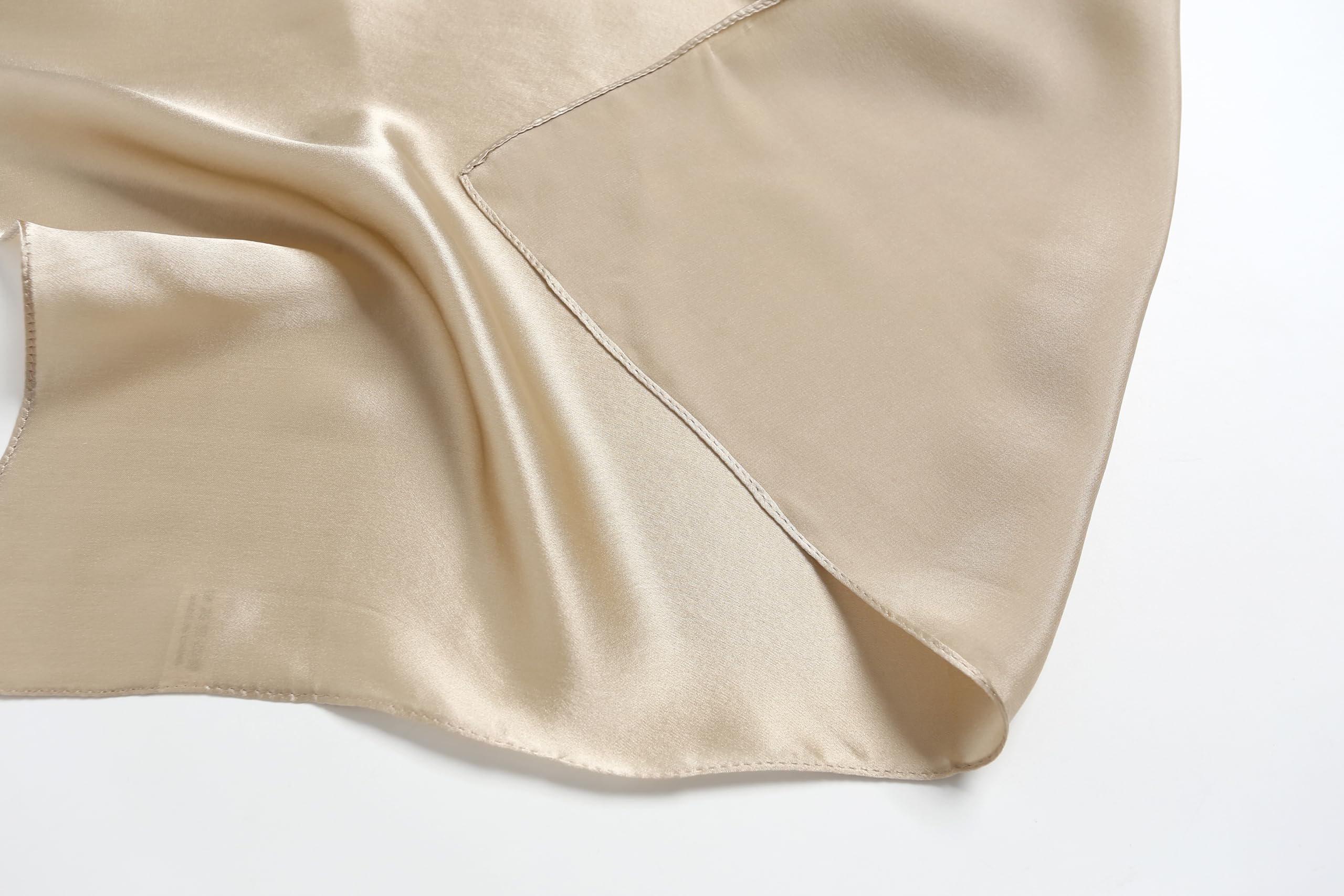 Diagonal fold of champagne beige silk with the stitched hem running across the corner