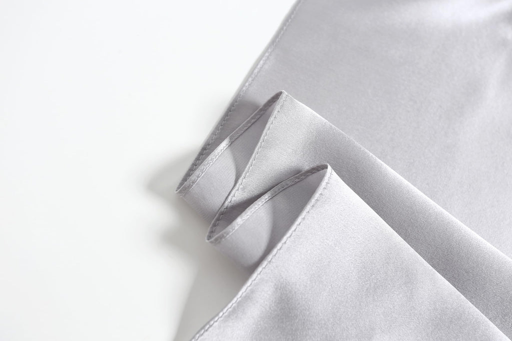 Close-up of the cloud grey square's narrow machine rolled hem along two folded edges