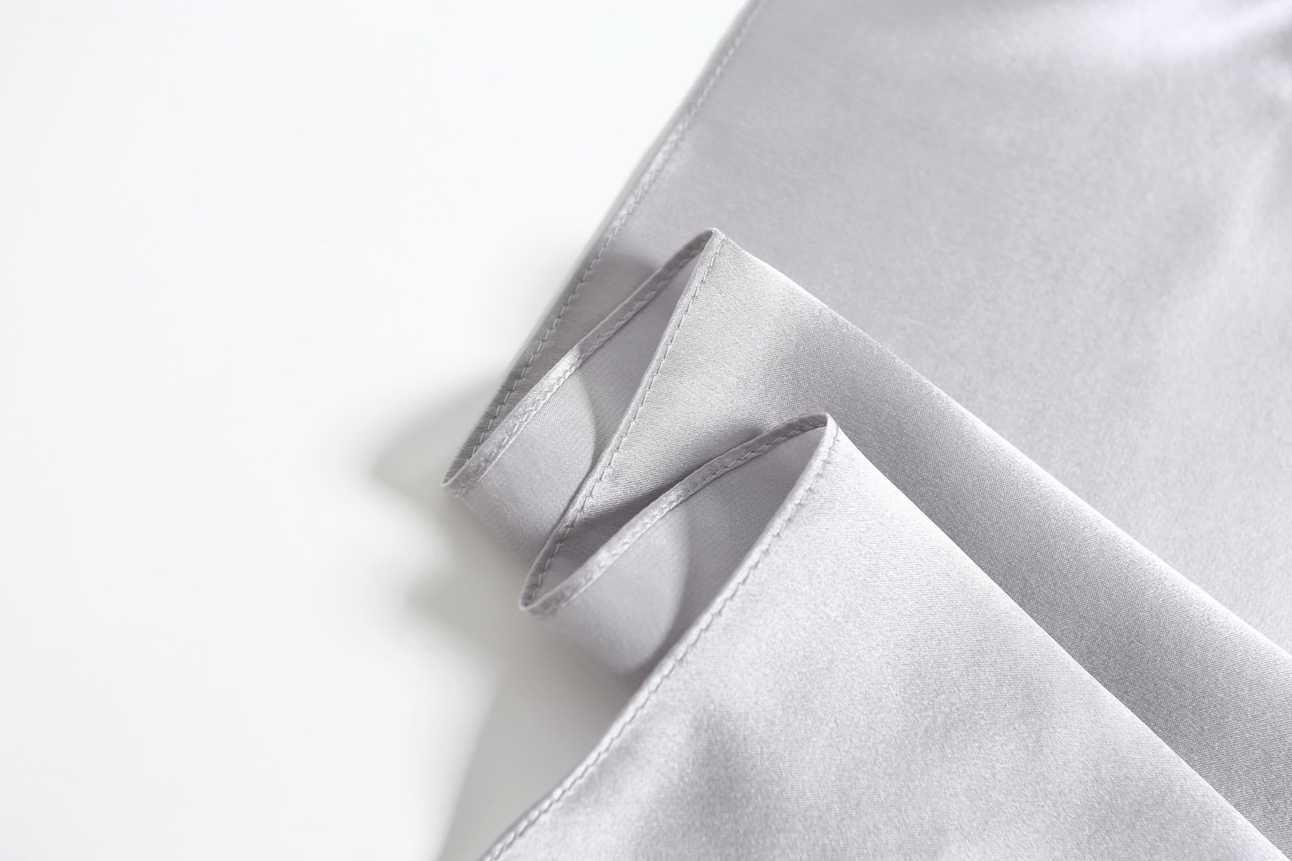 Close-up of the cloud grey square's narrow machine rolled hem along two folded edges