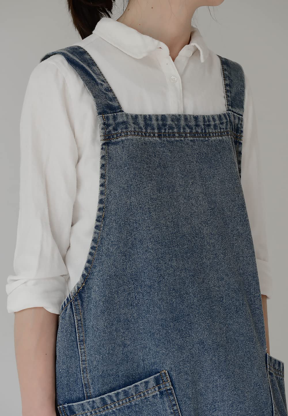 Close view of the denim shoulder strap and the topstitched patch pocket