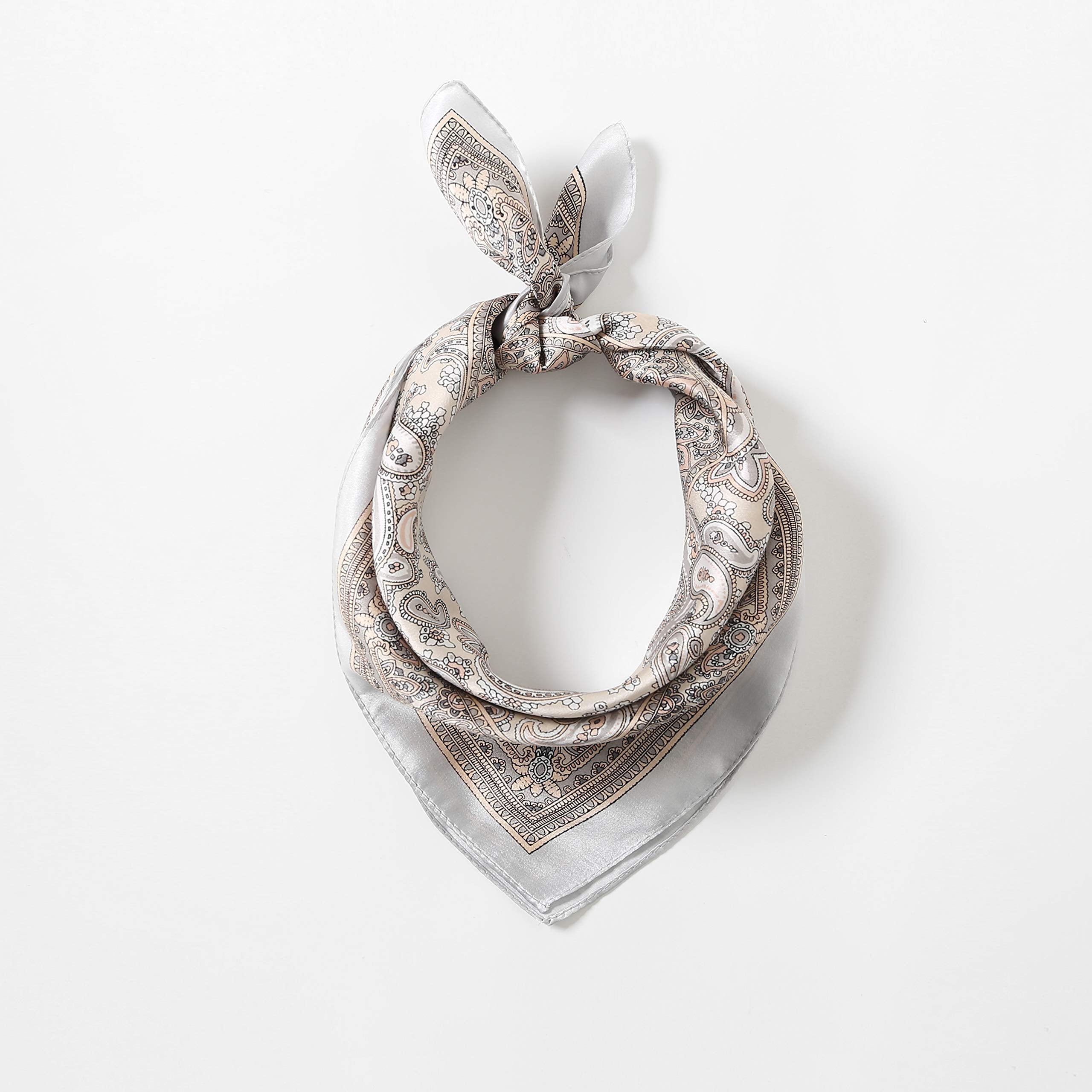 Taupe paisley square tied in a ring with a bunny-ear knot, tails fanned over pale grey