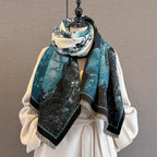 The shawl looped twice at the neck of a dress form with the cream fringed ends hanging long