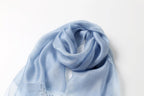 Denim blue shawl loosely knotted showing the soft drape of the fabric