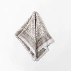 Cream paisley square folded to a diamond, pale grey band running along two edges