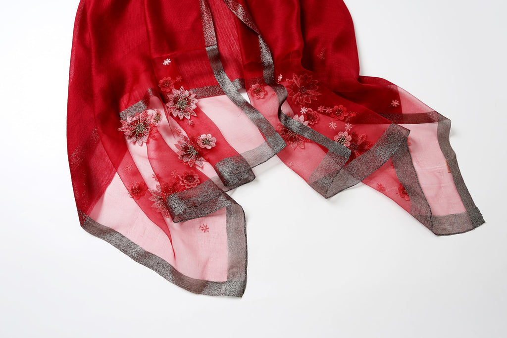 Angled view of the red embroidered end with the metallic woven border