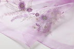 Close up of purple flowers leaves and hanging sprays worked in metallic thread