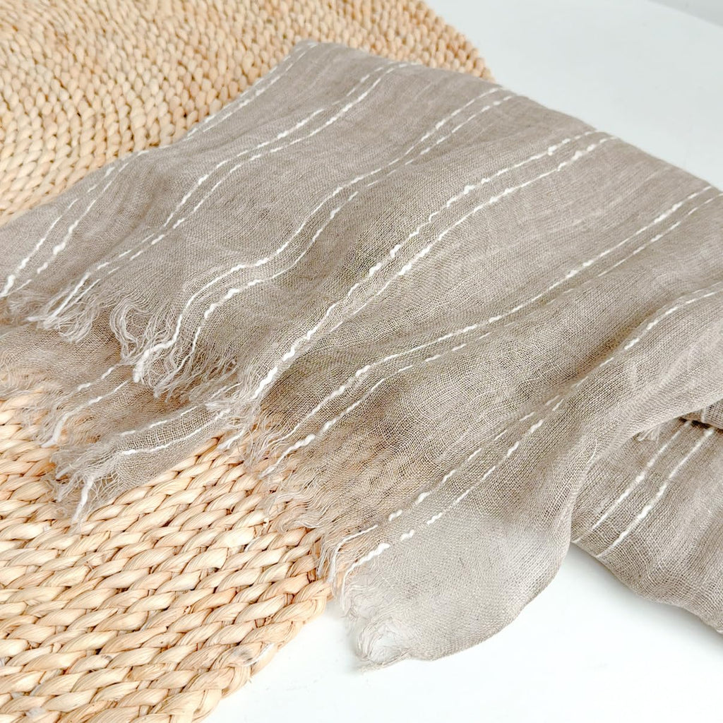 Close view of the raised white slub yarn stripes against the sheer flax ground