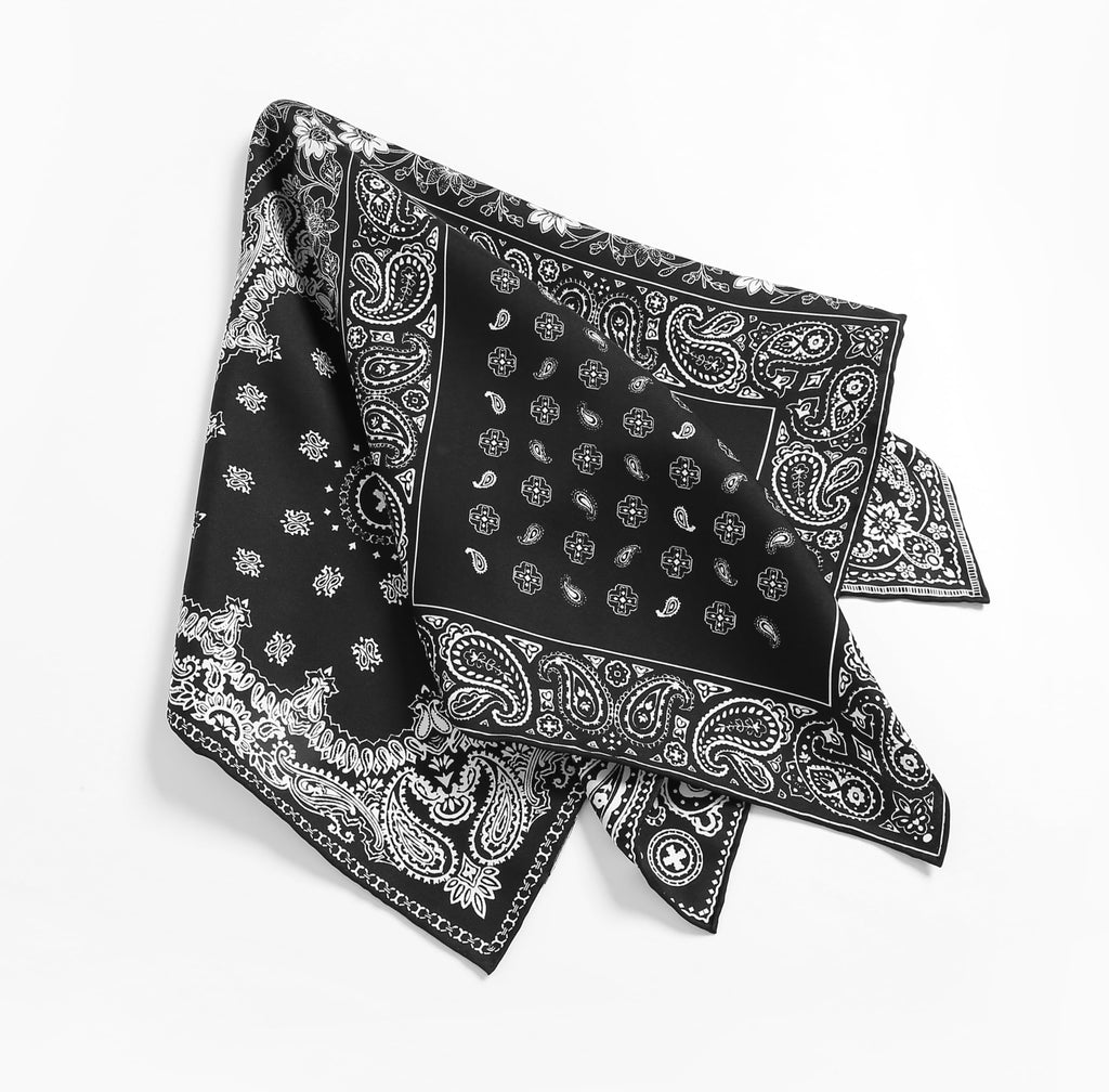Black bandana square laid out with corners lifted, white paisley border all round