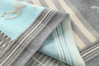 Macro of the pale blue and grey weave where a horse motif meets the cream stripe border