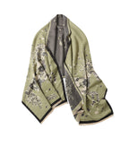 Sage green shawl folded to show the scattered dark blossom and the grey reverse with a black border