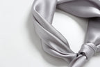 Cloud grey silk twisted into a collar shape with the knot resting off to one side