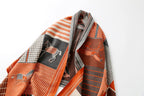 Close view of the shawl hanging in folds showing framed horse panels against orange and charcoal blocks