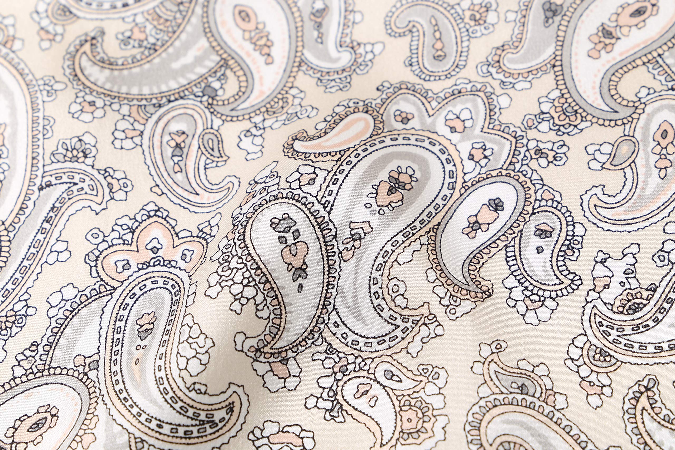 Macro of the print, fine taupe and apricot paisley teardrops on warm cream silk