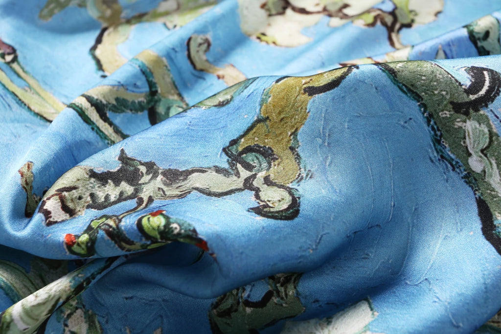 Detail of the painted branches and visible brush texture on the almond blossom silk scarf