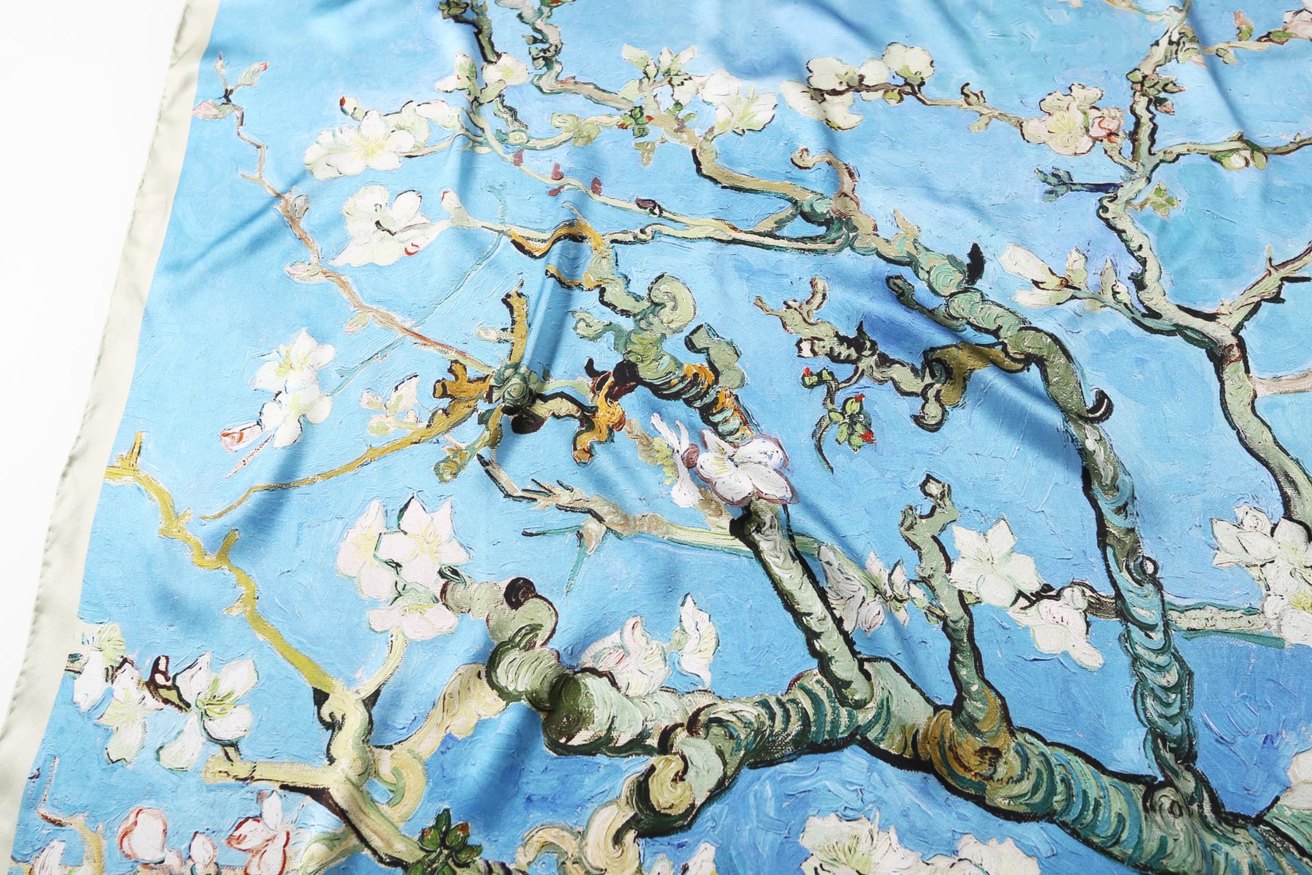 Close up of white almond blossom and twisting branches printed on blue silk
