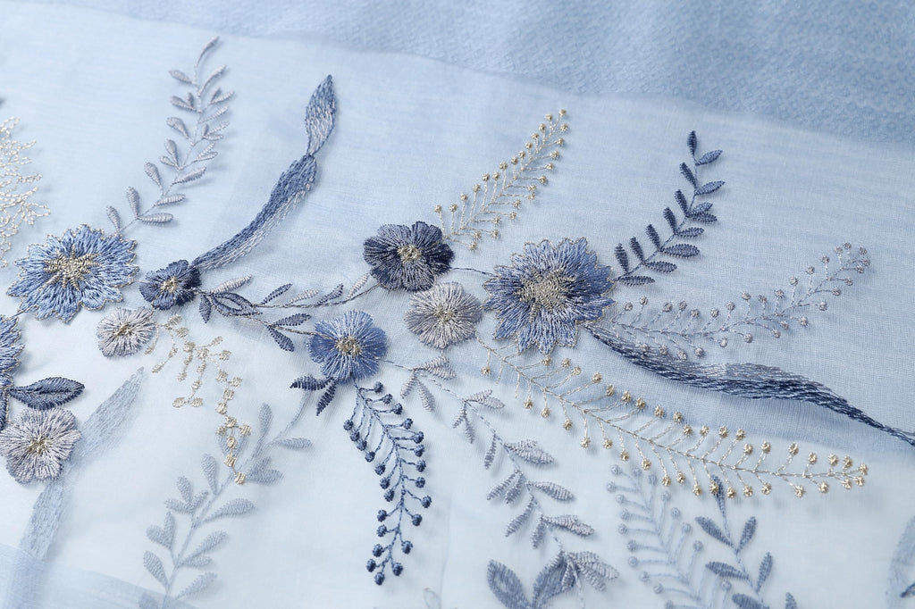 Close up of blue and silver thread flowers leaves and hanging sprays on the sheer ground