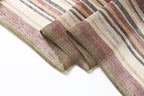 Close view of the folded scarf edge showing the loose weave and rose brown and olive stripes