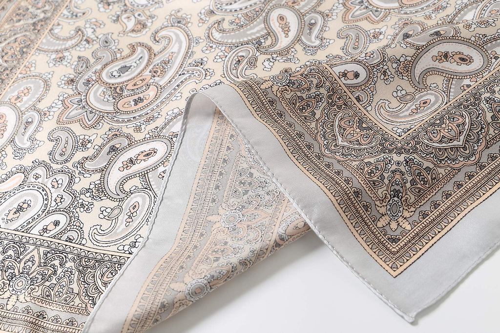 Folded edge close-up: apricot paisley border band above the narrow rolled hem